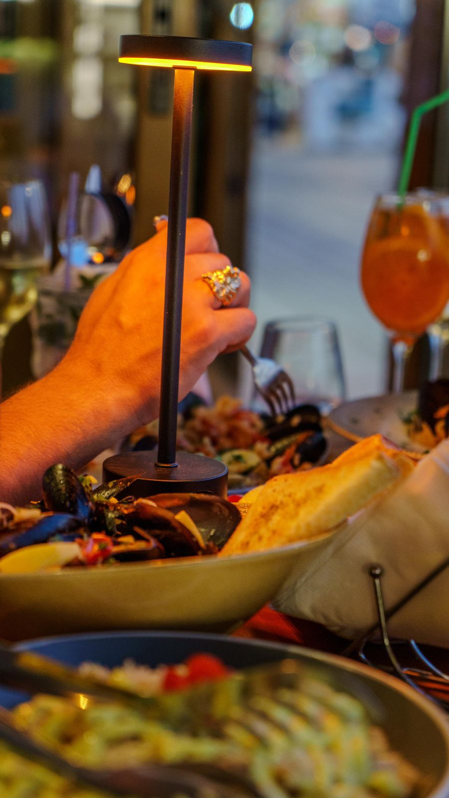 Wood-fired mussels served under a warm brass table lamp