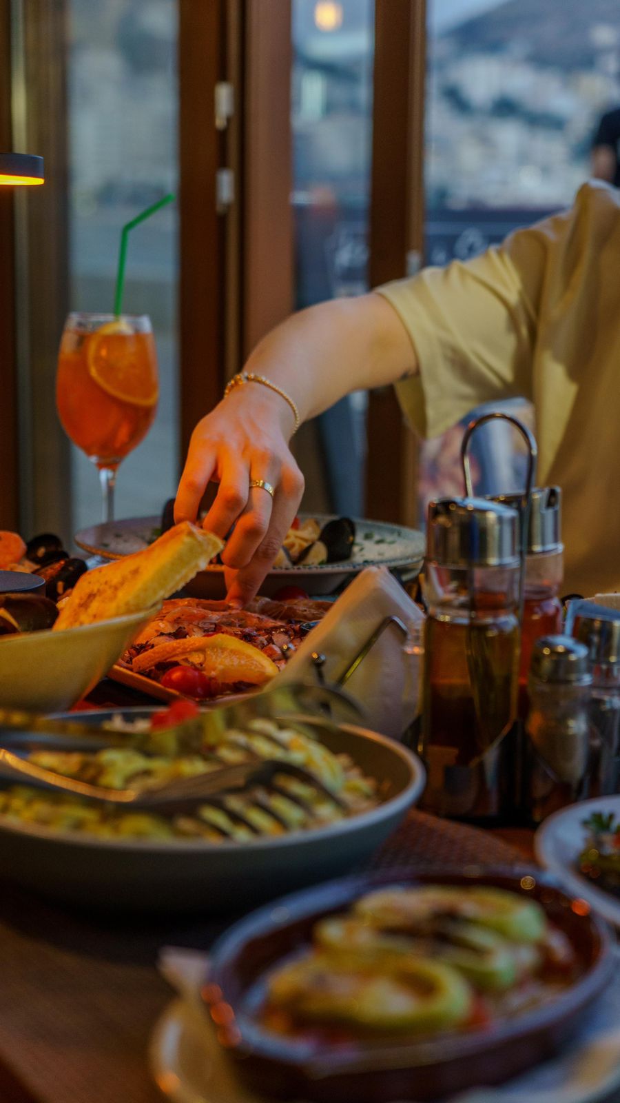 A hand reaching for bread across a seafood spread